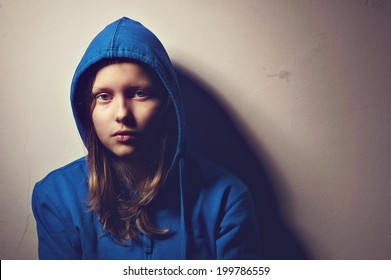 Sad teen girl in hood sitting