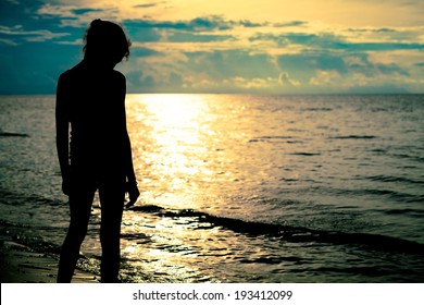 Sad Teen Girl Standing On The Beach At The Dawn Time