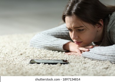 Sad Teen Waiting For Mobile Phone Message Lying On The Floor At Home