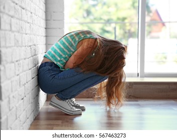 Sad Teenage Girl Sitting Near Window In A Room