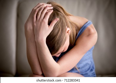 Sad teenager crying alone holding head in hands, feeling depressed, regrets of mistake, having problems, adolescent girl with broken heart, vulnerable teen suffers from dangerous addiction, close up