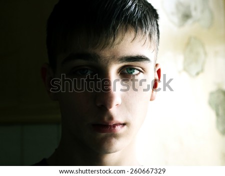 Similar – Boy with a white T-shirt in front of a dark wall