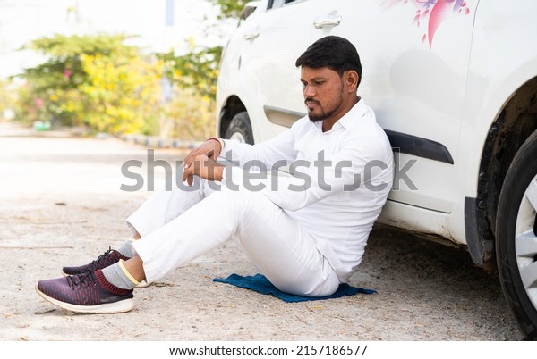 Sad\
thoughtful cab driver sitting by leanings to car on road - concept\
of business loss, bankrupt and family\
problems