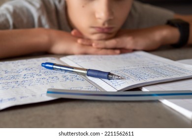 Sad tired boy sitting and looking in to books and notebooks. Education, school, learning difficulties, dyslexia concept - Powered by Shutterstock