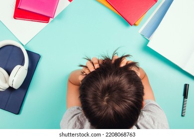 Sad Tired Frustrated Teenage Boy Sitting At The Table With Many Books, Digital Tablet Computer And Headphones. Online Learning, Reading Difficulties, Education Concept