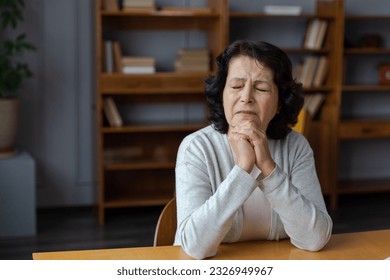 Sad tired ill sick lonely disappointed older senior woman sitting at home alone. Unhappy mature grandmother experiencing grief relative death bad news. Stressed elder lady suffering from loneliness