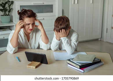 Sad And Tired Mother And Son Are Engaged In Distance Learning Using A Tablet At Home.