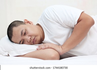 Sad Unhappy Asian Man Lying On Bed With Blank Stare, Hard To Sleep Thinking Of Bad Situation, Emotional Expression