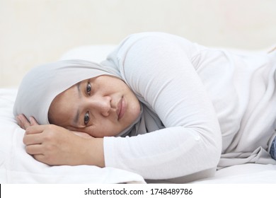 Sad Unhappy Asian Muslim Woman Lying On Bed With Blank Stare, Hard To Sleep Thinking Of Bad Situation, Emotional Expression