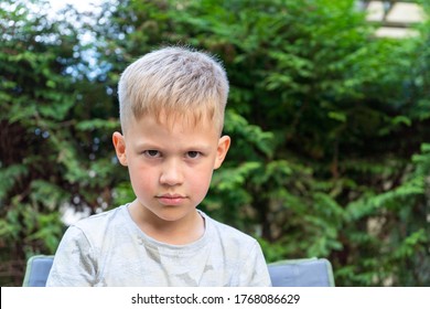 Sad And Unhappy Boy Looking Into Camera. Spoiled, Arrogant, And Annoyed Child  Concept. 