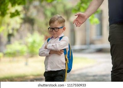 Sad And Unhappy Child With Backpack And Parent Hand. Upset Toddler Boy. Problem Child. Concept For Bullying, Depression Stress Or Frustration. On School Background. Back To School