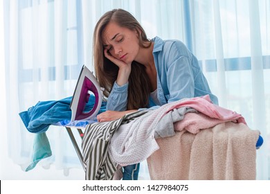 Sad Unhappy Ironing Woman Feeling Tired From Ironing Pile Of Clothes After Laundry At Home.