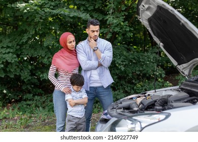 Sad Unhappy Pensive Muslim Man, Lady In Hijab And Little Son Stand Near Broken Car With Open Hood Outdoor In Summer. Problems On Road, Car Breakdown, Family Trips, Holidays Together And Auto Trip