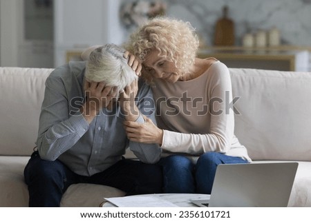 Sad unhappy senior couple going through crisis, problem, bad news, eviction notice, medical checkup result. Mature wife giving support, empathy, comfort to frustrated desperate husband
