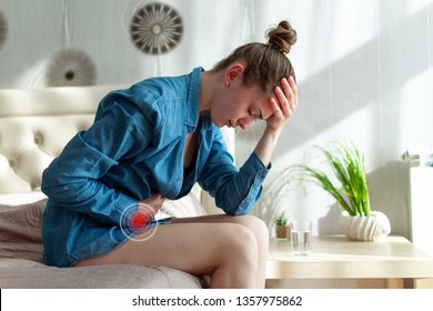 Sad, unhappy woman suffering from PMS and menstruation pain. Having stomach ache, abdominal pain and headache because of critical days. Inflammation and infection bladder, cystitis. Health problems