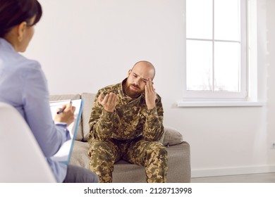 Sad Upset Depressed Veteran Soldier Suffering From PTSD Having Therapy Session With Professional Military Psychologist, Sitting On Couch, Thinking About Horrors Of War, Sharing Concerns And Worries