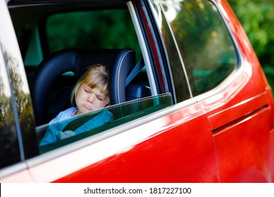 Sad Upset Little Kid Girl Sitting In Car In Traffic Jam During Going For Summer Vacation With His Parents. Tired, Exhausted Child Not Happy About Long Journey. Crying Baby.