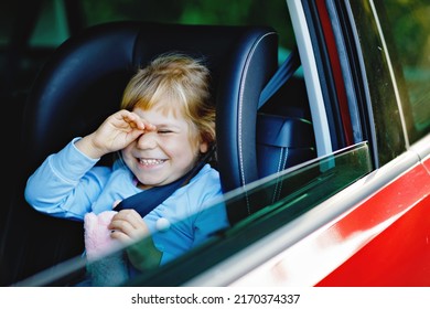 Sad Upset Little Kid Girl Sitting In Car In Traffic Jam During Going For Summer Vacation With His Parents. Tired, Exhausted Child Not Happy About Long Journey. Crying Baby.