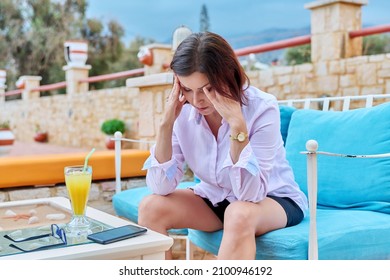 Sad Upset Mature Woman Sitting Outdoors At Table In Cafe With Smartphone