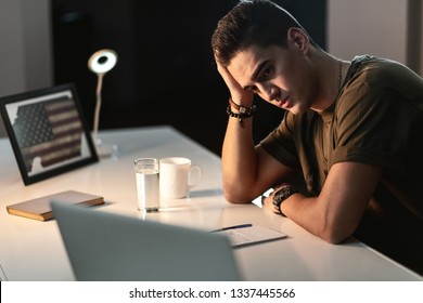 Sad US Army Soldier Thinking About Home While Sitting At Desk And Writing A Letter. 