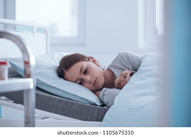 Sad And Weak Girl Lying Alone In The Hospital Bed