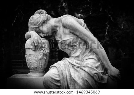 Sad and weeping woman sculpture. Sad grieving expression sculpture with sorrow face down thinking crying. Black and white BW photography. 