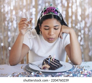 Sad Woman Birthday Cake, Celebrate Home Alone With Champagne And Sad At Lonely Pandemic Party Celebration. Young Latino Girl Fail To Blow Candle On Table, Wish Thinking And Shiny Crown Decoration