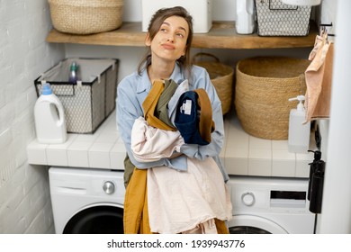 Sad woman with clothes in the landry at home - Shutterstock ID 1939943776