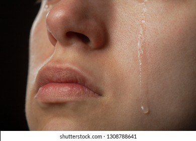 sad woman cries, shot a close up of female cheek with a tear drop