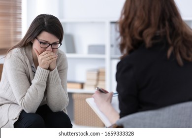 Sad woman crying during psychotherapy at professional clinic