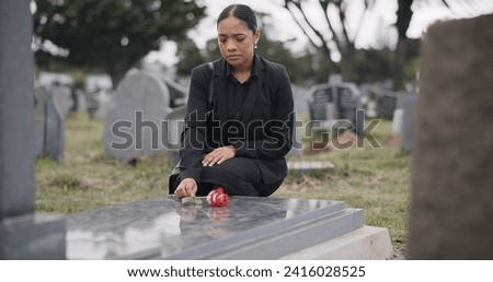 Sad woman, graveyard and rose on tombstone in mourning, loss or grief at funeral or cemetery. Female person with flower in depression, death or goodbye at memorial or burial service for loved one