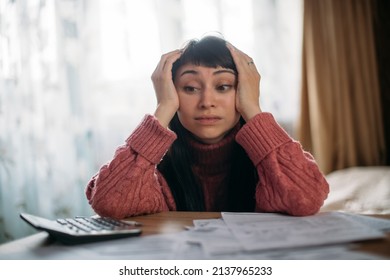 Sad Woman Holding Her Head Over Utility Bills. The Concept Of Rising Prices For Heating, Gas, Electricity. A Young Worried Dissatisfied Girl Looks At Papers Does Not Expect A High Cost Of Services.