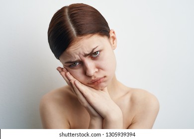 sad woman holds hands by face - Shutterstock ID 1305939394