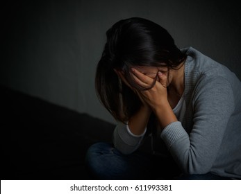 Sad Woman Hug Her Knee And Cry. Sad Woman Sitting Alone In A Empty Room.