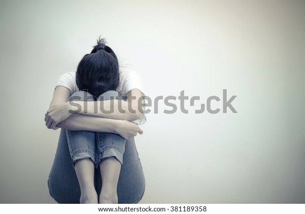 sad woman hug her knee and\
cry
