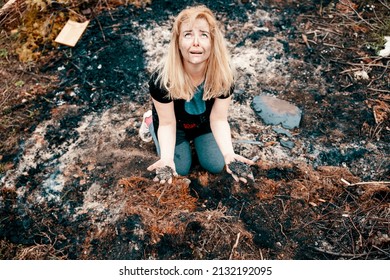 Sad Woman Kneeling At Burn House Yard After Disaster. Female In Emotional Pain Looking Up The Sky. Natural Disaster, Extreme Weather, Bombing, War Concept. Selective Focus. Copy Space