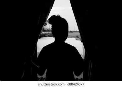 Sad Woman Looking Outside The Apartment Window. Silhouette Windows