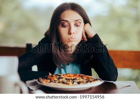 Sad Woman Looking at the Pizza in Her Plate. Female obsessing over counting calories thinking about eating fast-food 
