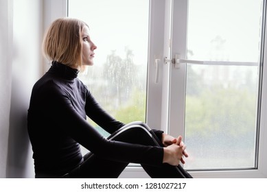 Sad Woman Looking Through The Glass Window With A Rain Drops.