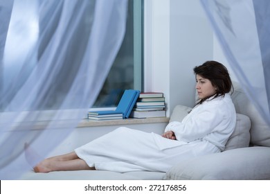 Sad Woman Lying On The Bed In Dressing Gown