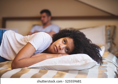 Sad woman lying on bed after an argument with her boyfriend.