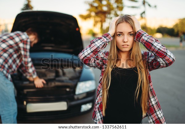 Sad woman,\
man against open hood on the\
background