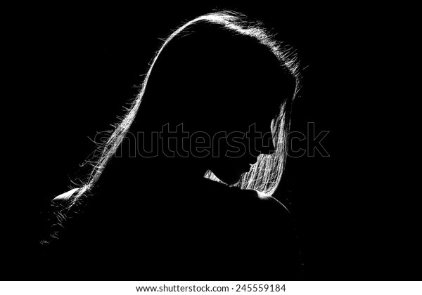 sad\
woman profile silhouette in dark, monochrome\
image