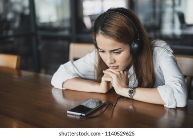 Sad Woman Relaxing By Listening Song With Earphones And Smartphone.