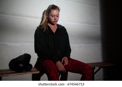 Sad woman relaxing on bench in fitness studio - Powered by Shutterstock