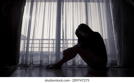 Sad Woman Sitting Alone Near Window