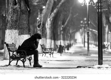 Sad Woman Sitting On A Bench In Winter Time.