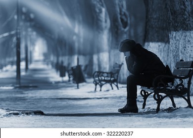 Sad Woman Sitting On A Bench In Winter Time.