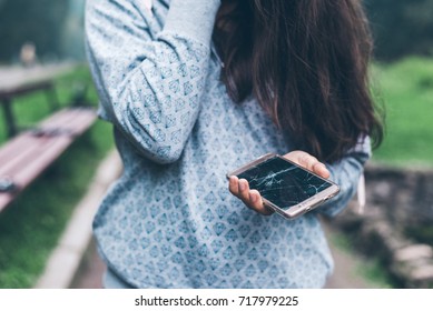 Sad Woman Sitting On The Bench With Cracked Phone