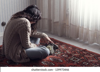 Sad Woman Sitting On The Floor Waiting For The Phone Call